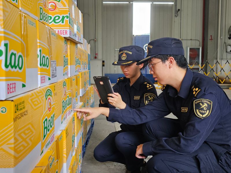 图为：海关关员在磨憨铁路口岸对进口老挝啤酒进行查验  刘加文摄