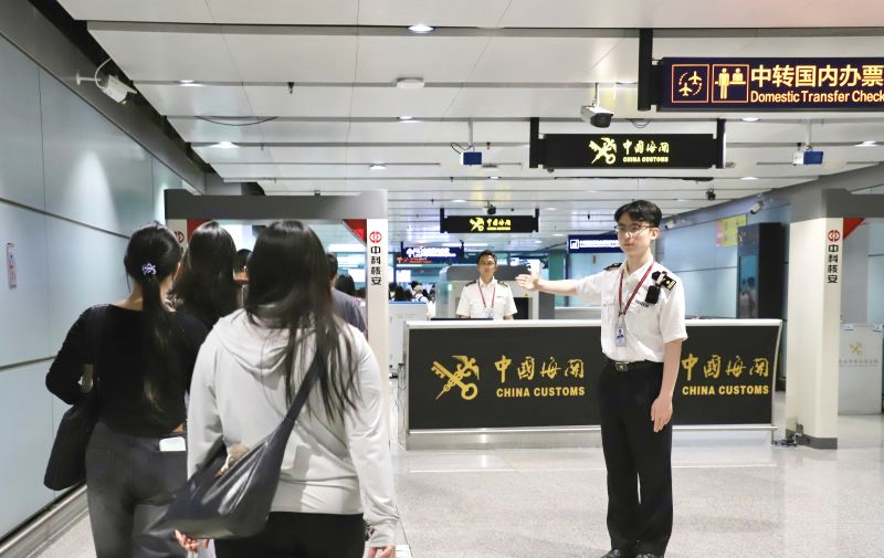 海关关员在昆明机场口岸“国际转国内”通程通道引导旅客通关 马舒娴 摄